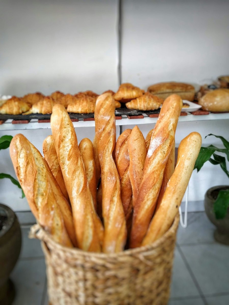 Baguettes dorées rangées debout dans un panier en osier