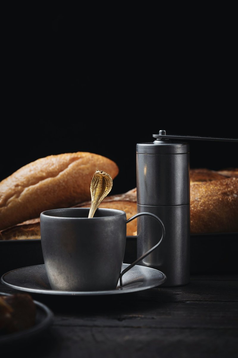 Tasse de café, moulin à café et pain posés sur un fond sombre
