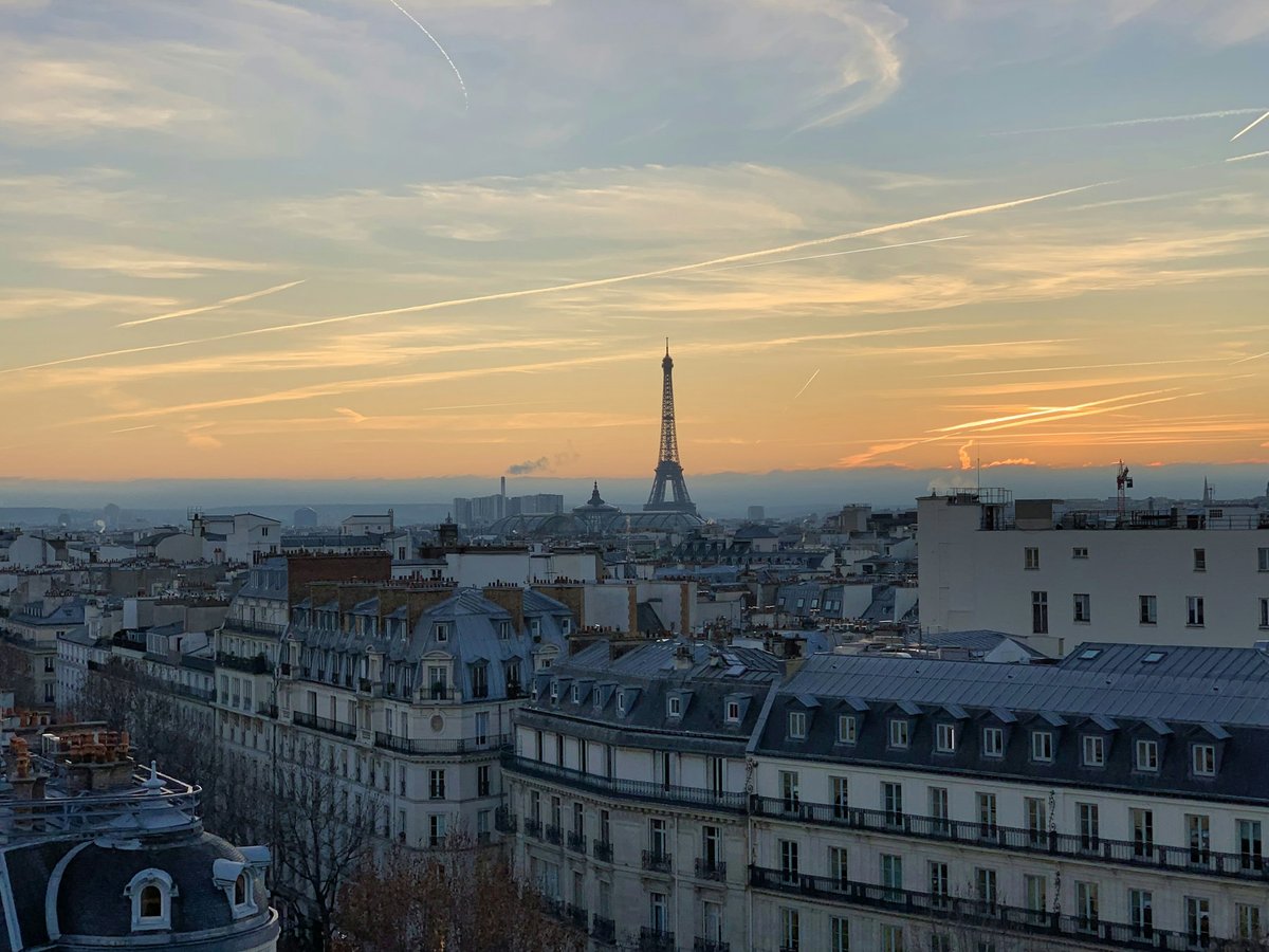 Toits de Paris au coucher du soleil, la tour Eiffel à l'horizon